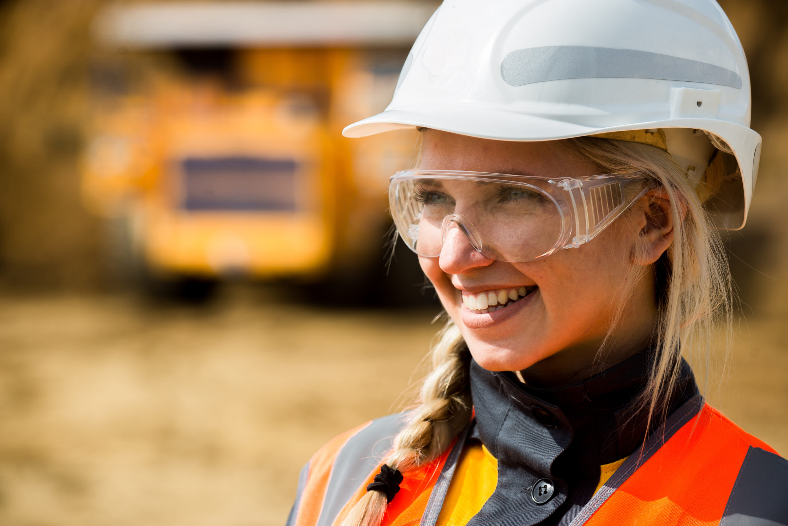 Women in construction wearing a white hard hat and hi viz protective clothing.